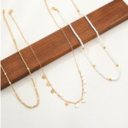 Three-layered gold necklace set with pearl beads, rhinestones, and disc pendants in a boho style at spotngrab lebanon