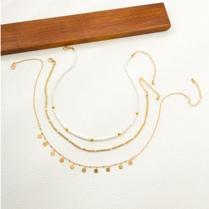 Three-layered gold necklace set with pearl beads, rhinestones, and disc pendants in a boho style at spotngrab lebanon