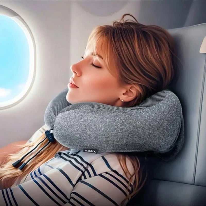 A traveler resting comfortably on an airplane seat using the Hoco HX70 memory foam neck pillow available at Spotngrab Lebanon.