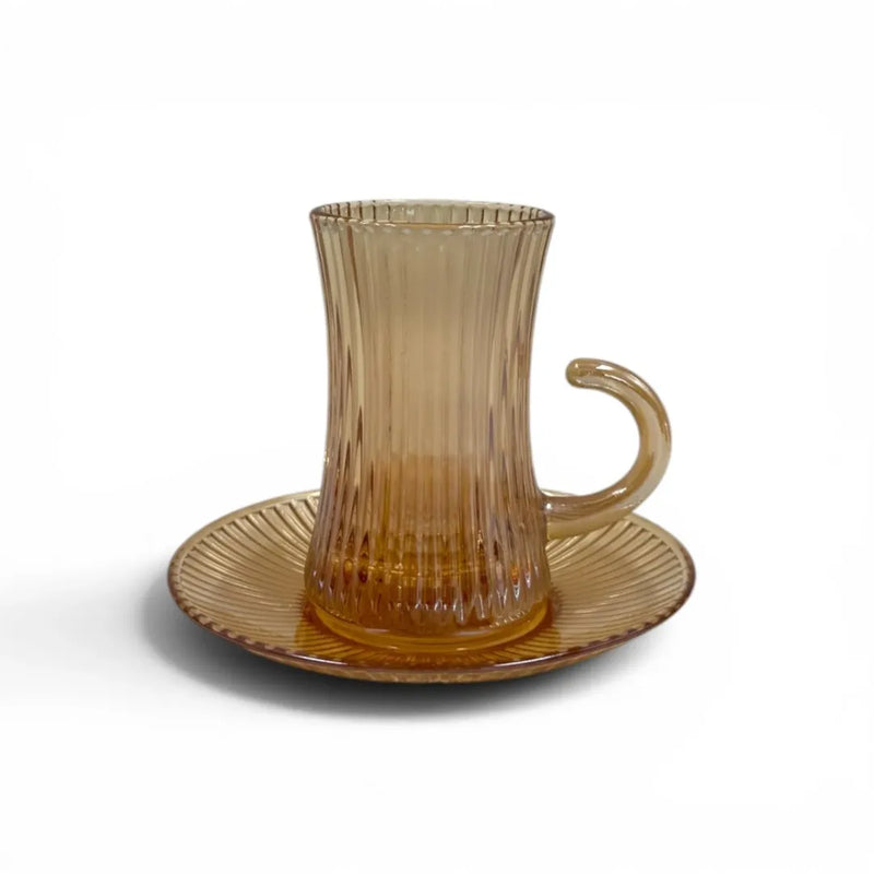 A complete 1 piece amber glass tea service set showing 100ml vertical ribbed cups with handles sitting on their matching fluted saucers on Spotngrab Lebanon.