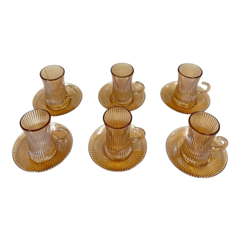 A complete 12-piece amber glass tea service set showing six 100ml vertical ribbed cups with handles sitting on their matching fluted saucers on Spotngrab Lebanon.