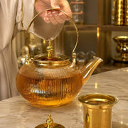 Elegant 1000ml amber tinted clear borosilicate glass teapot with a modern ribbed body pattern, gold-colored lid, and matching gold handle on Spotngrab Lebanon.