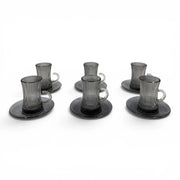 A complete 12-piece smoky grey glass tea service set showing six vertical ribbed glasses with handles sitting on their matching fluted saucers on Spotngrab Lebanon.