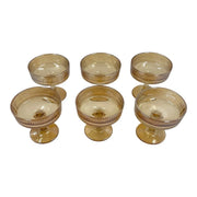 A set of six short-stemmed amber glass champagne coupes displaying a distinct vertical ribbed ripple pattern across their wide shallow bowls on Spotngrab Lebanon.