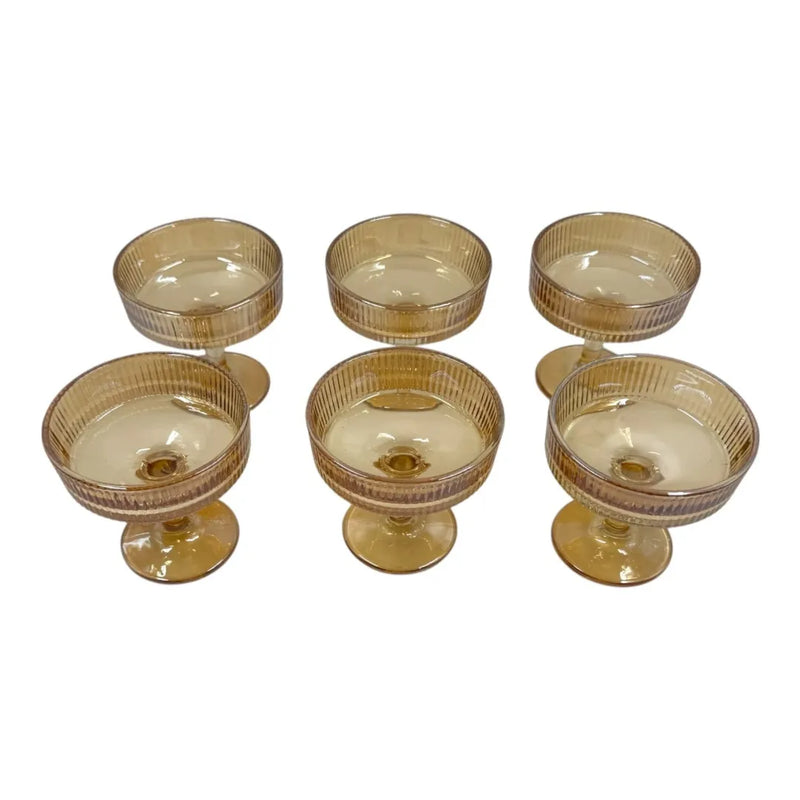 A set of six short-stemmed amber glass champagne coupes displaying a distinct vertical ribbed ripple pattern across their wide shallow bowls on Spotngrab Lebanon.