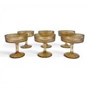 A set of six short-stemmed amber glass champagne coupes displaying a distinct vertical ribbed ripple pattern across their wide shallow bowls on Spotngrab Lebanon.