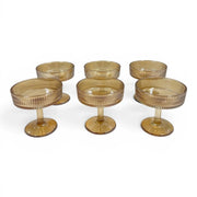 A set of six short-stemmed amber glass champagne coupes displaying a distinct vertical ribbed ripple pattern across their wide shallow bowls on Spotngrab Lebanon.